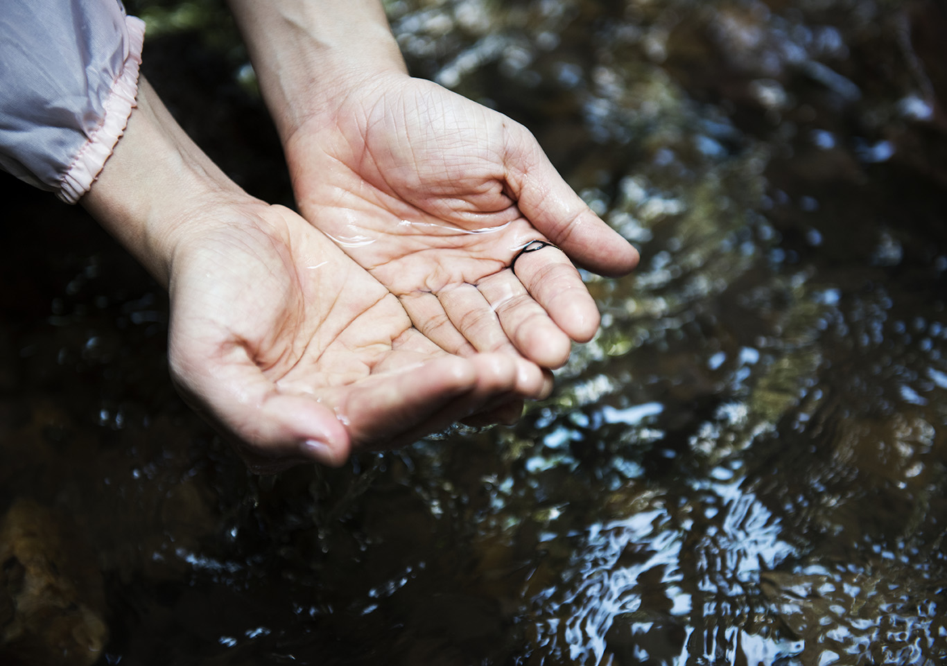 Woman Getting Some Water From The River To Drink